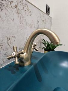 ein Waschbecken mit einem goldenen Wasserhahn auf einer blauen Theke in der Unterkunft Good Times Accomodation Cuneo in Cuneo