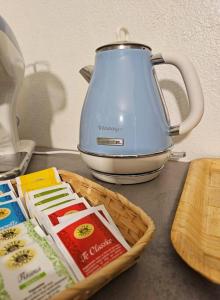 a tea kettle and a basket of food on a counter at Good Times Accomodation Cuneo in Cuneo