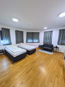 Cette grande chambre comprend deux lits et un canapé. dans l'établissement Vienna´s Danube Apartments, à Vienne