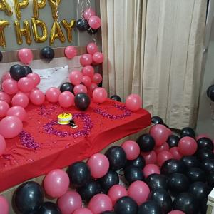 a birthday party with pink and black balloons at Radhe Krishna Luxury stay in Mathura