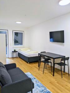 - un salon avec un canapé, une table et un lit dans l'établissement Vienna´s Danube Apartments, à Vienne
