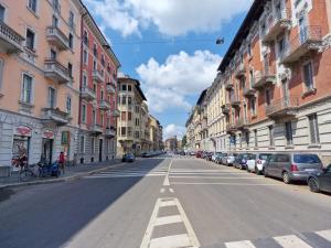 une rue urbaine vide avec des voitures garées sur le côté de la route dans l'établissement Sunny House, à Milan