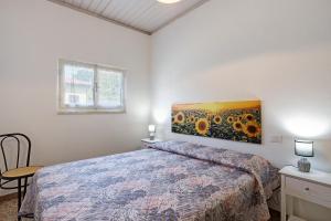 une chambre avec un lit et un tableau de tournesols dans l'établissement Casa Tortora vicino al mare, à Massa