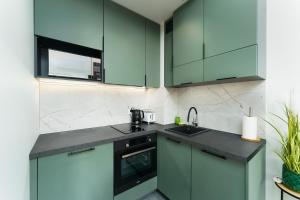 a kitchen with green cabinets and a sink at Apartament Emerald z Basenem Letnim by HolidaySun in Sianozety