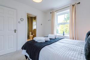 a white bedroom with a bed with two pillows on it at Detached 5 bed House in Worsley Manchester in Worsley