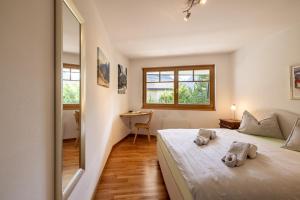 1 dormitorio con cama, escritorio y espejo en Trü-Sura Nr. 3 en Scuol
