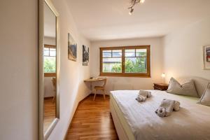 a bedroom with a bed and a desk and a mirror at Trü-Sura Nr. 3 in Scuol