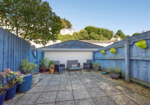 a backyard with a blue fence and chairs and plants at 4 Hesketh Mews in Torquay