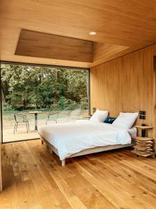 um quarto com uma cama grande e uma janela grande em Bleu Minuit La Source em Wolxheim