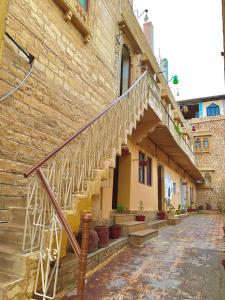 un edificio de piedra con una escalera en su lateral en Hotel Sandstone Villa,, en Jaisalmer