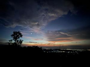een silhouet van een boom voor een zonsondergang bij Sinurambi Bed & Breakfast - Mills Residence in Penampang
