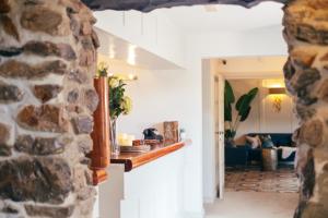 uma vista para uma sala de estar com uma parede de pedra em Ty Afon - River House em Beddgelert