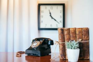 um relógio e um telefone sobre uma mesa com uma planta em Ty Afon - River House em Beddgelert