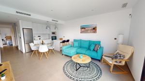 a living room with a blue couch and a table at Villa Morera - A Murcia Holiday Rentals Property in Los Alcázares