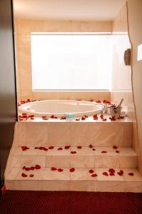 a bathroom with a tub with red roses on the floor at Hotel Carrera in Lima