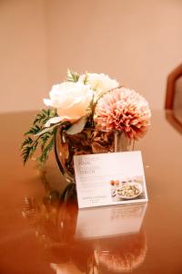 a vase with flowers and a card on a table at Hotel Carrera in Lima