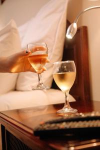 dos copas de vino en una mesa junto a una cama en Hotel Carrera, en Lima