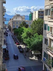 a city street with cars parked in a parking lot at OLGAS SQUARE APARTMENT CKBSM in Patra