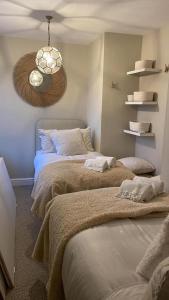 a bedroom with two beds and a clock on the wall at Luxury apartment, 60 High St, St Martins in Lincolnshire