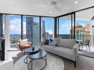a living room with a couch and a view of a city at Spire Residences by the Spire Manager in Brisbane