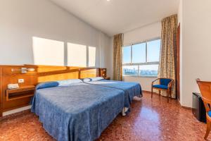 Habitación de hotel con cama, escritorio y ventana en Port Europa, en Calpe