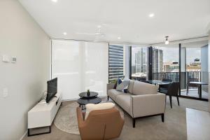 a living room with a couch and a tv at Spire Residences by the Spire Manager in Brisbane