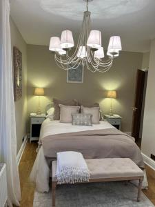 - une chambre avec un grand lit et un lustre dans l'établissement Luxury apartment, 60 High St, St Martins, à Lincolnshire