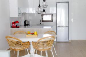 a kitchen with a white table with chairs and a refrigerator at Beautiful Condo in Laguna Beach Resort overlooking Laguna Rosa In Torrevieja With 2 Bedrooms and 2 Bathrooms in Torrevieja