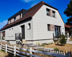 een wit huis met een bruin dak bij Villa de prestige vue sur Baie de Canche in Le Touquet-Paris-Plage