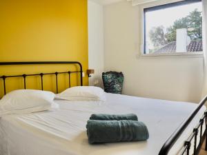 een groot wit bed met een groene handdoek erop bij Villa de prestige vue sur Baie de Canche in Le Touquet-Paris-Plage