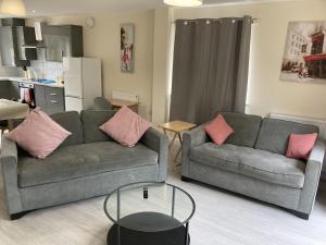 a living room with two couches and a table at Newly built 3 Bed house with ample parking 1 in Balderton