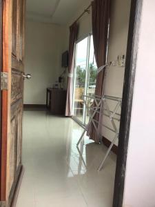 een hal met een kamer met een raam en een stoel bij Hassana Apartment in Krabi town