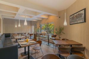 un restaurante con paredes de madera, mesas y sillas en Hotel Osetia Garden en Momchilgrad