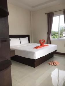 a bedroom with a bed with an orange towel on it at Hassana Apartment in Krabi town