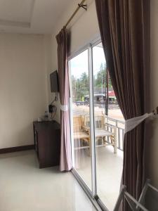 Habitación con una puerta corredera de cristal que da a un balcón. en Hassana Apartment en Krabi