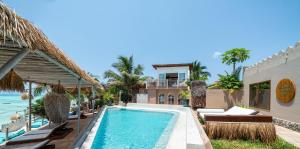 a villa with a swimming pool next to a building at Coral Rocks Hotel & Restaurant in Jambiani