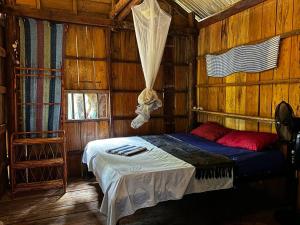 a bedroom with a bed in a wooden cabin at Easy Tiger Garden Bungalows - by Beach House Cambodia in Koh Rong Sanloem