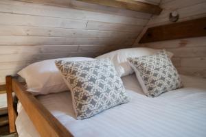 a bed in a wooden room with two pillows at Atlantis in Holbeton