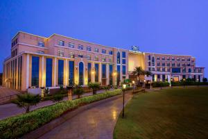 un gran edificio con ventanas azules por la noche en The Gaurs Sarovar Premiere, en Ghaziabad