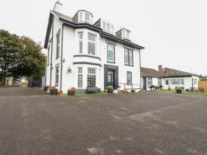 a white house with a black roof at Seaview Wellness Retreat in Carnoustie