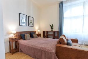 a bedroom with a bed with a couch and a window at Narodni - Old Town Residence in Prague