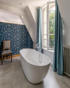 baño con bañera blanca y ventana en Château de Bonaventure, en Aulnoy
