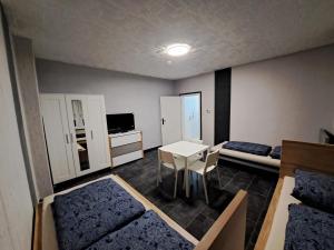 a room with a room with two beds and a table at Ferienwohnung mit Tageslichtbad in ländlicher Lage nahe Halle (Saale) in Landsberg