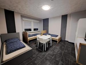 a room with two beds and a table in it at Ferienwohnung mit Tageslichtbad in ländlicher Lage nahe Halle (Saale) in Landsberg
