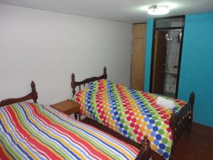 Una cama con un edredón colorido en un dormitorio en Cusco's Flat, en Cusco