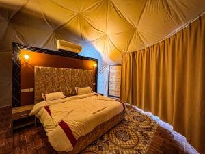 Sky Light Wadi Rum في وادي رم: غرفة نوم بسرير كبير في خيمة
