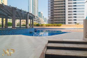 a swimming pool in a city with tall buildings at Marco Polo - Cozy Apt Close to Metro, Beach Dubai Marina Mall in Dubai