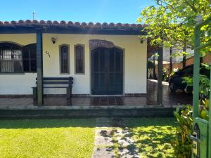 a house with a bench in the front yard at Cantinho da Lagoa in Araruama