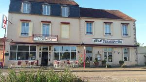 a building with tables and chairs in front of it at Le Terminus in Pont-dʼAisy