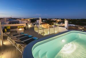 uma piscina no telhado de um edifício em Villa Benagil with stunning views and roof terrace with private heated pool em Lagoa